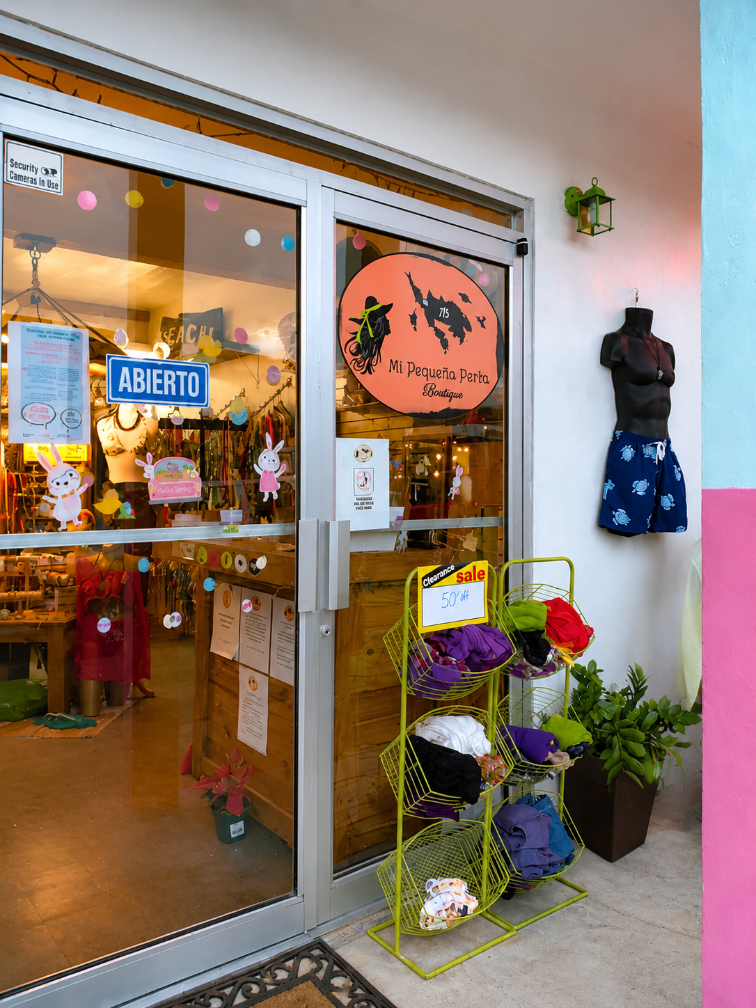 Mi Pequeña Patria Boutique — glass storefront with orange logo and colorful clearance display in downtown Culebra