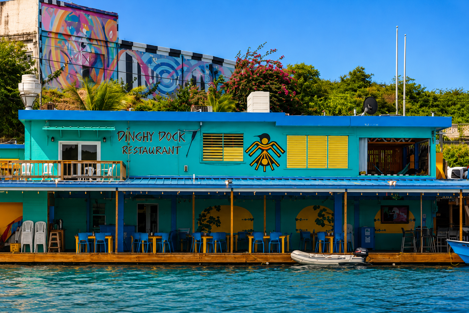 Dinghy Dock Restaurant — turquoise waterfront building with yellow shutters on Ensenada Honda