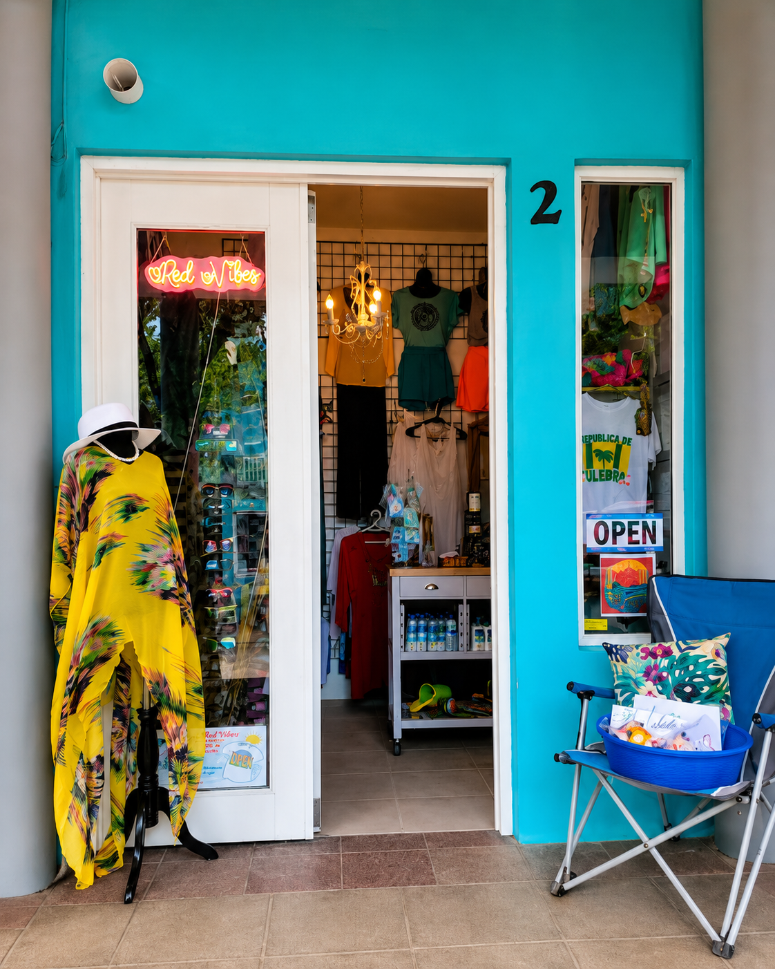 Red Vibes — turquoise storefront with yellow tropical dress and neon sign in downtown Culebra
