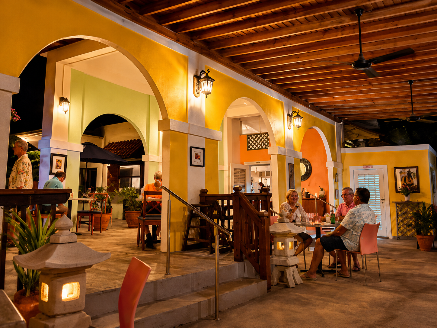 Susie's — warmly lit dinner patio with yellow arches and guests dining in an intimate setting
